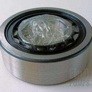 A metal roller bearing is lying on its side against a neutral white background.